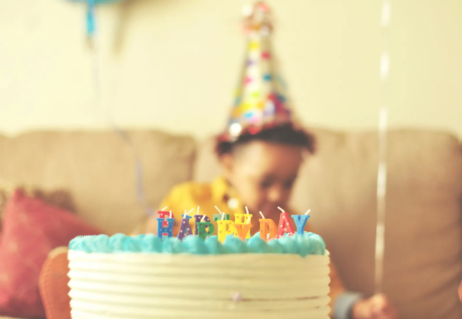 Birthday cake and a kid sitting in the couch celebrating