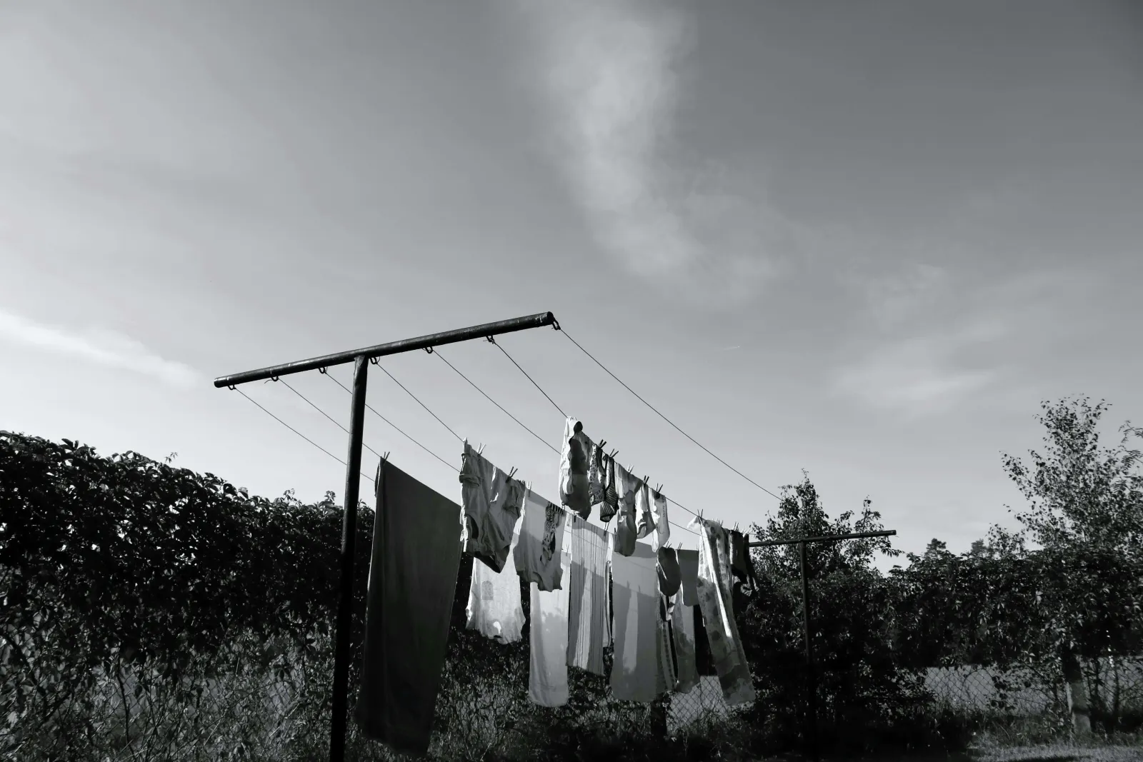 Black and white photo of laundry hanging on a clothesline outdoors