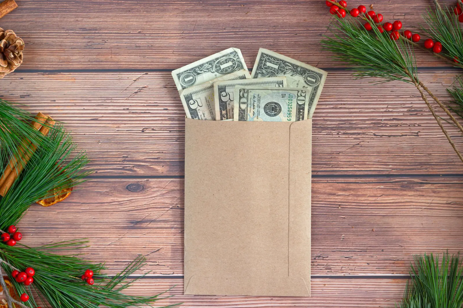 Kraft envelope stuffed with cash bills on a wood table