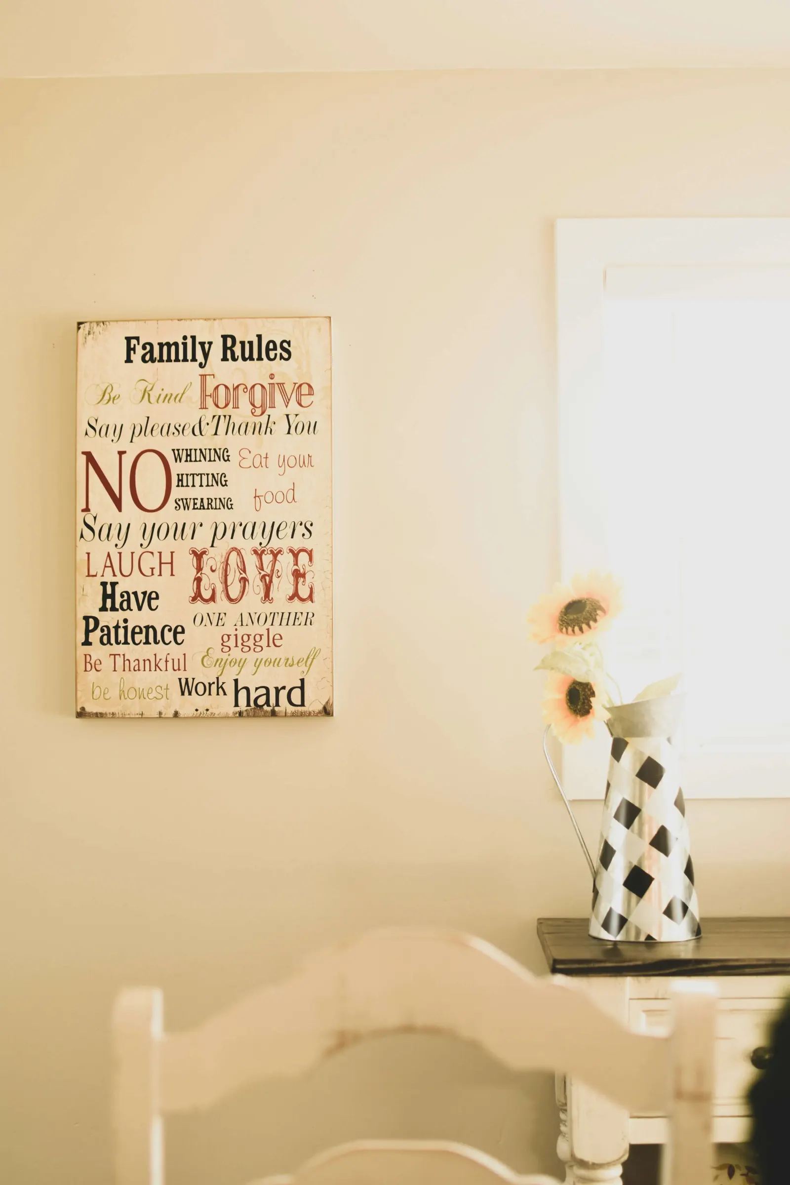 Family Rules wall sign beside a sunflower vase on a side table