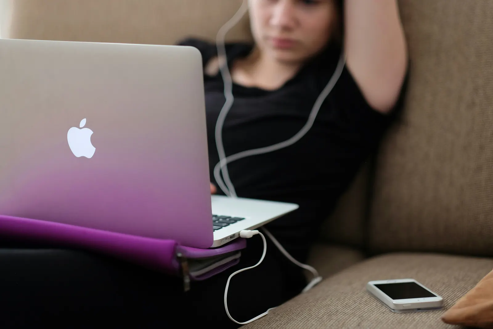 Girl using her mac computer in the couch