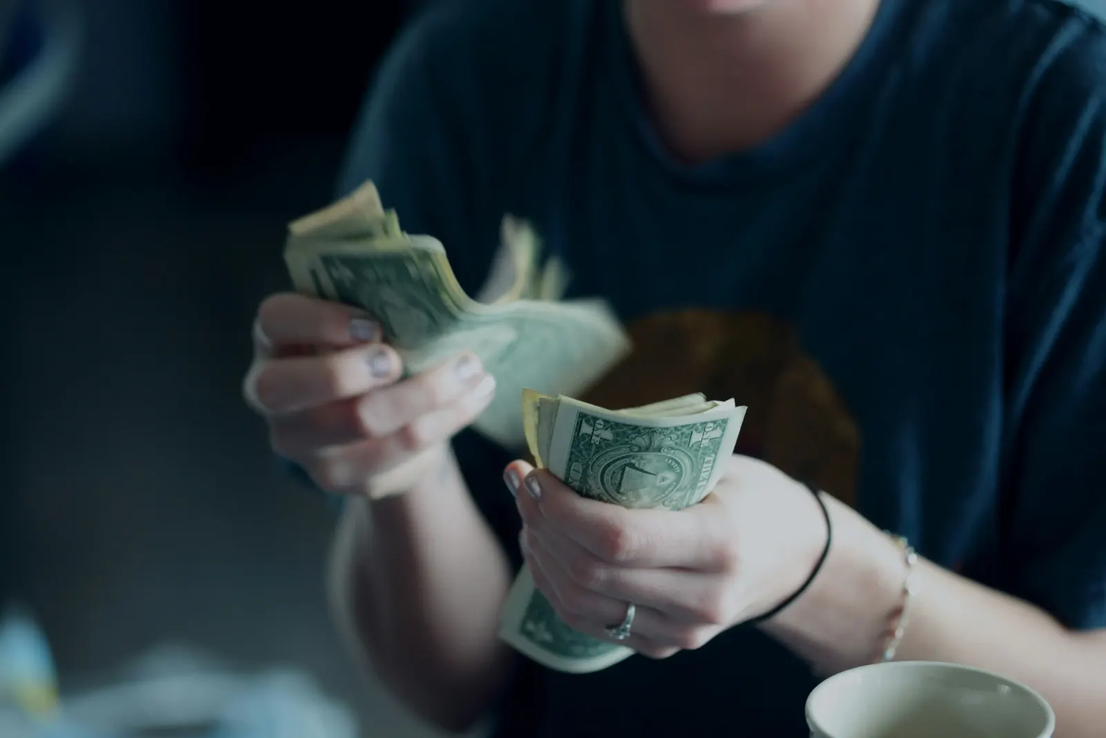 Hands counting a stack of dollar bills