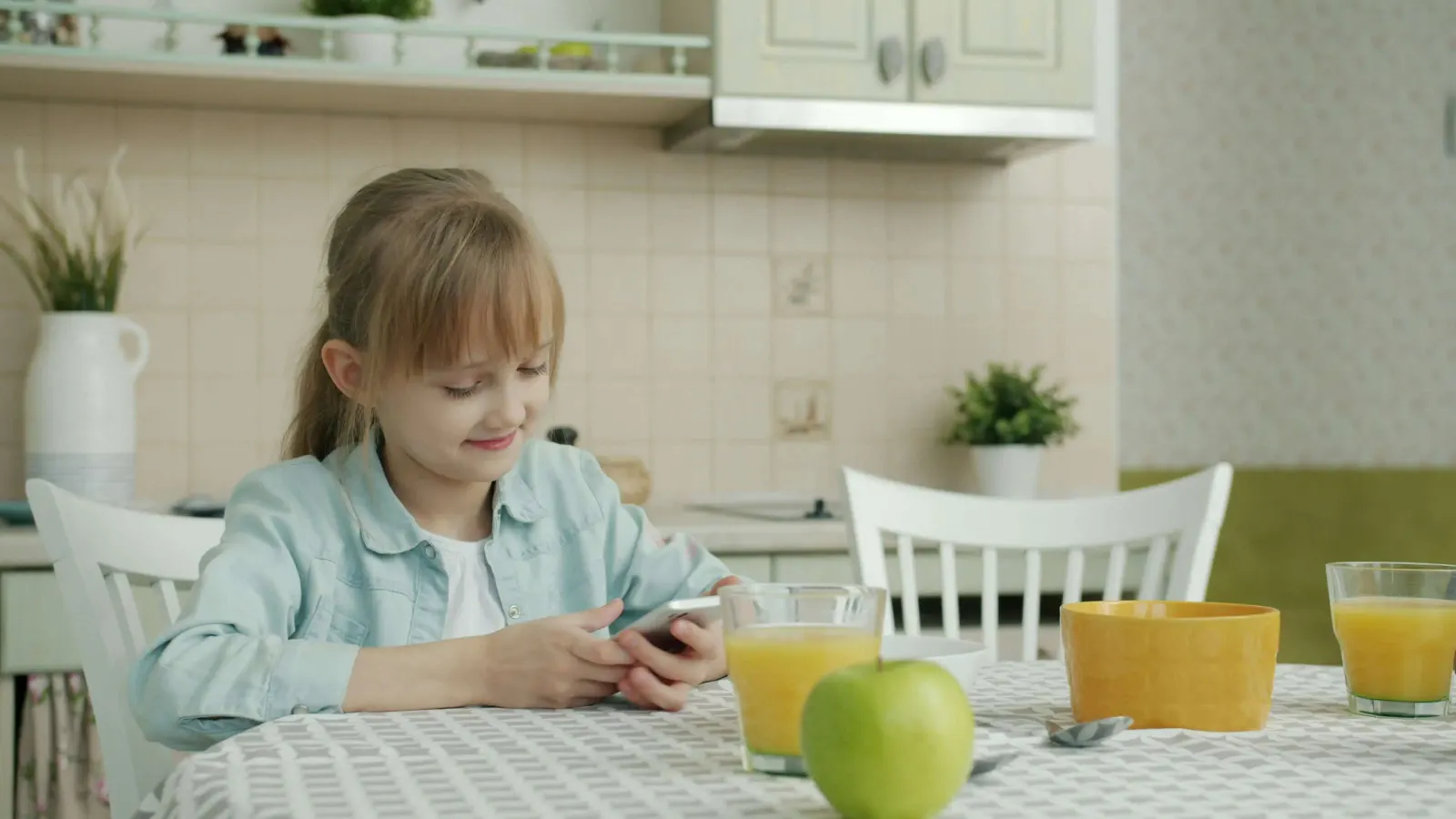 Girl using phone in the kitchen