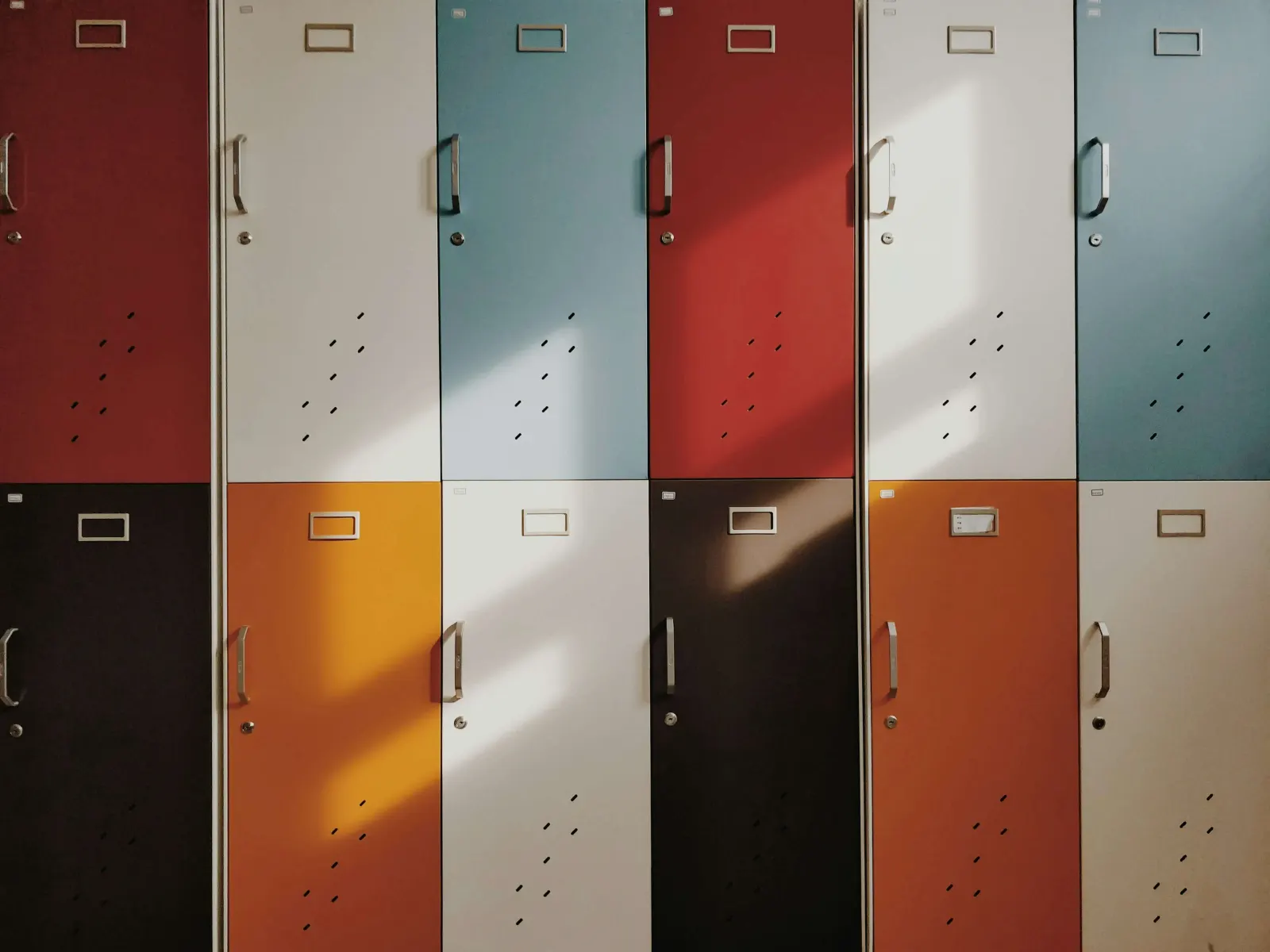 Row of colorful school lockers with sunlight streaming across them