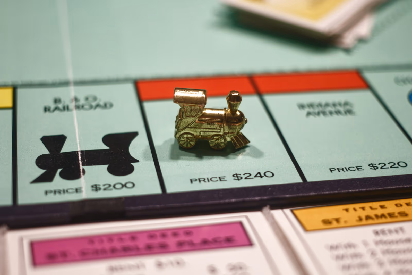 close-up of a toy train game piece on a Monopoly board