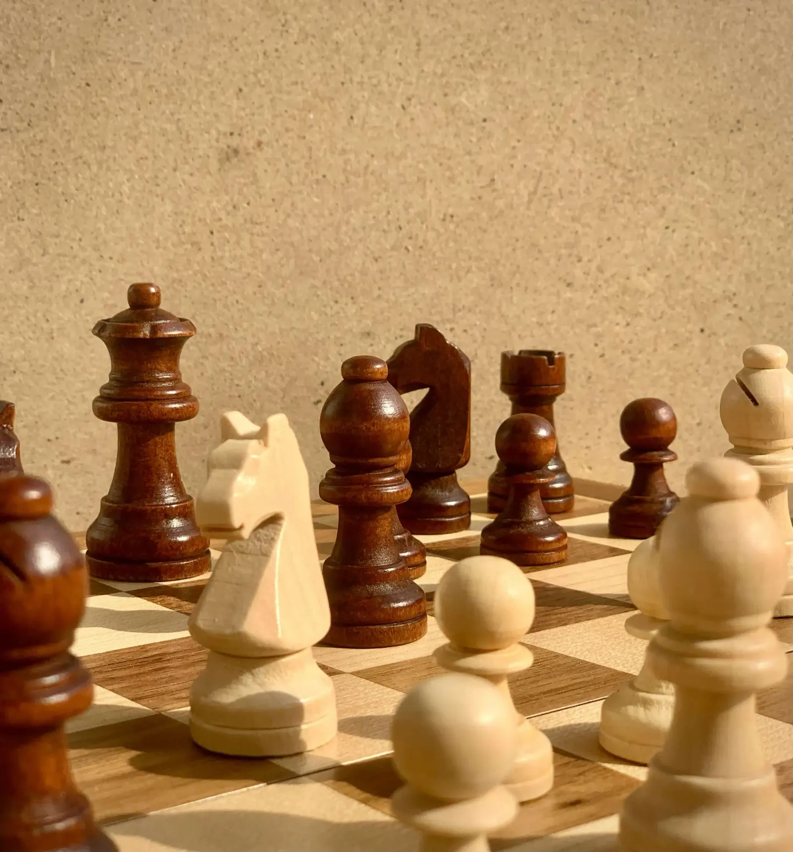Wooden chess pieces set up mid-game on a chessboard