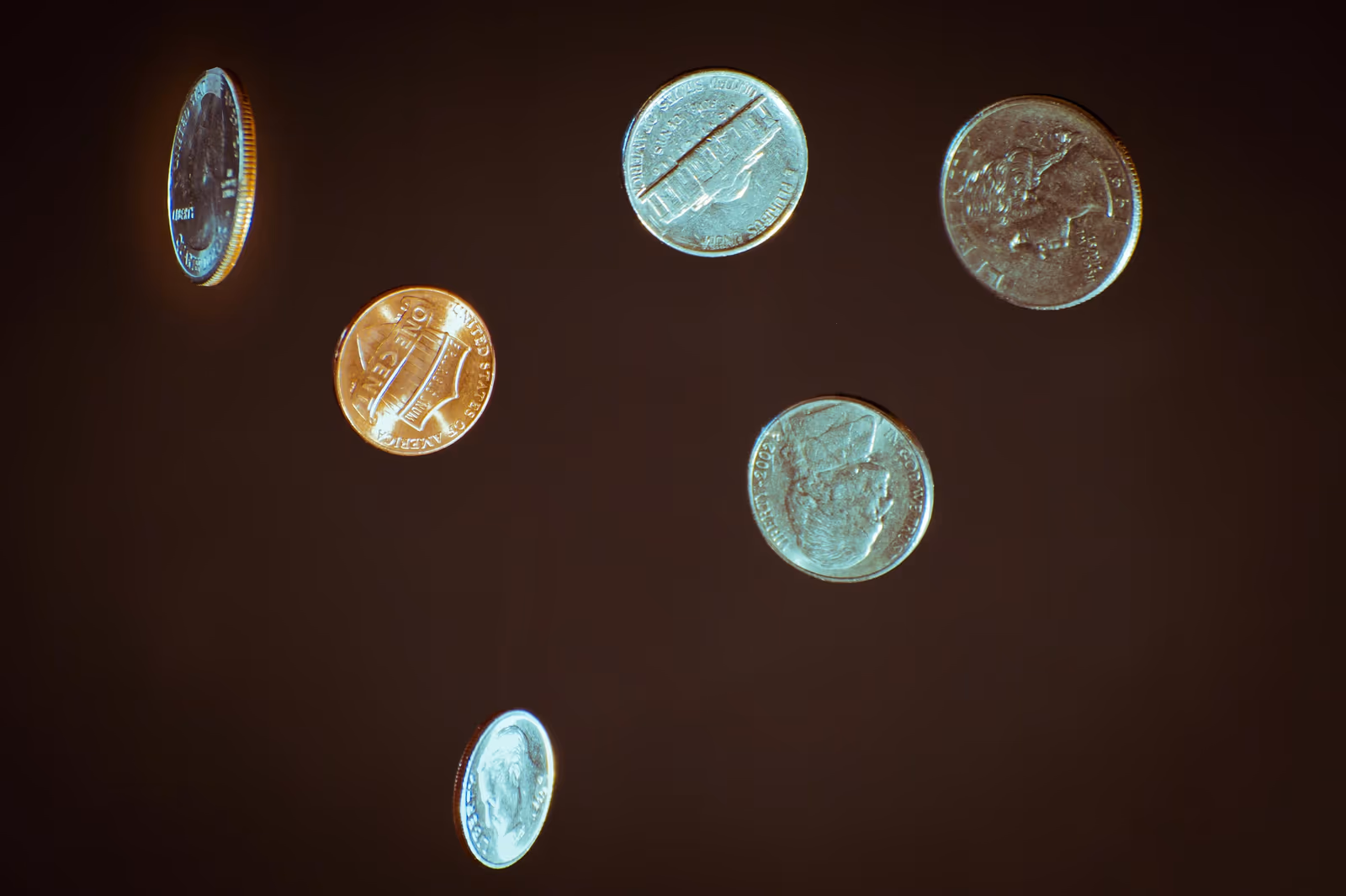 Close-up of loose US coins floating against a dark background