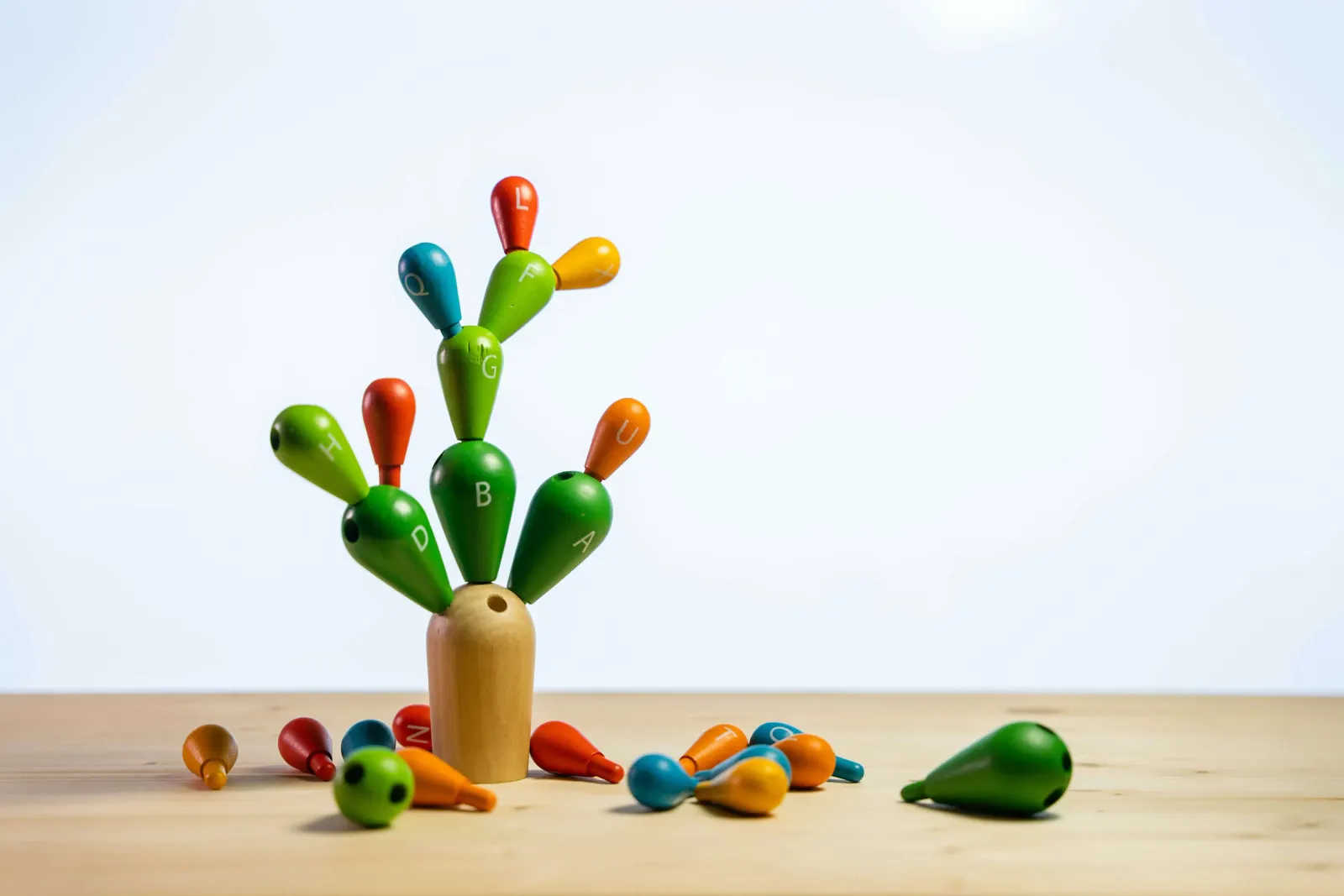 Colorful wooden cactus-shaped stacking toy with lettered pieces