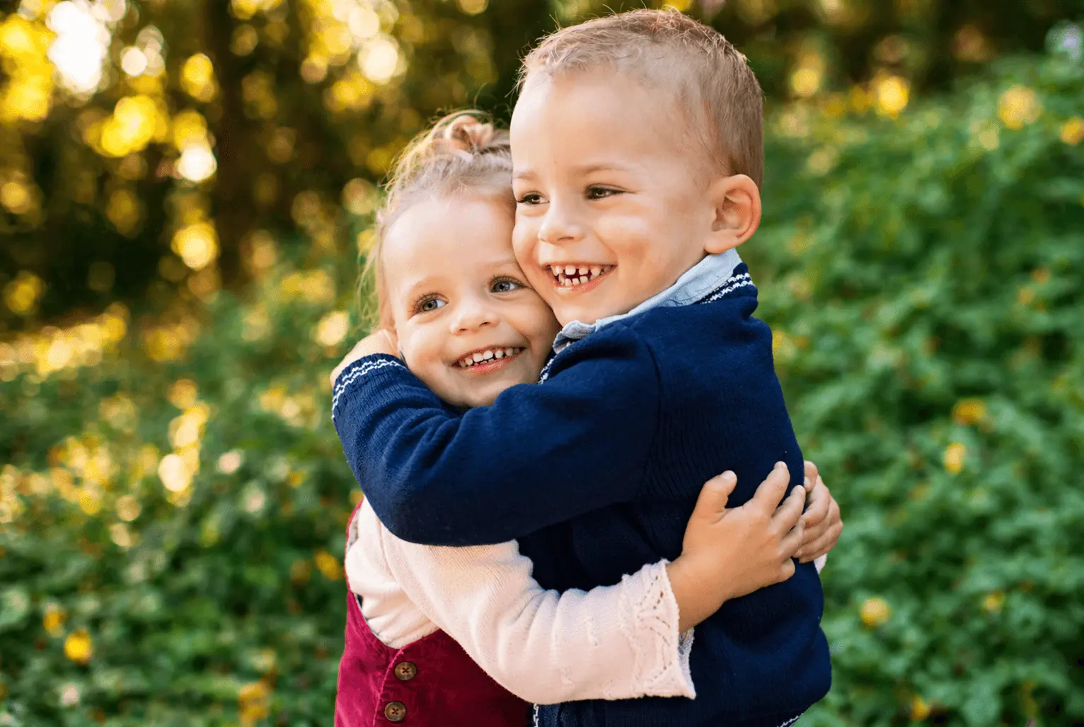 Siblings hugging in a garden